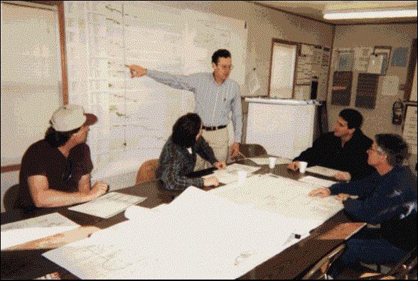 Figure 1: This photo was taken in a construction planning office in 1998. Some important characteristics of this process are unchanged in the past thirty years, e.g., there are multiple participants in the process, although probably many other important stakeholders are absent from the meeting.