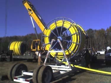 Some of the trailers are simply A-frames on wheels that can carry and deploy pipe but require a crane to load/unload. Others incorporate a means of lifting the reels into place.