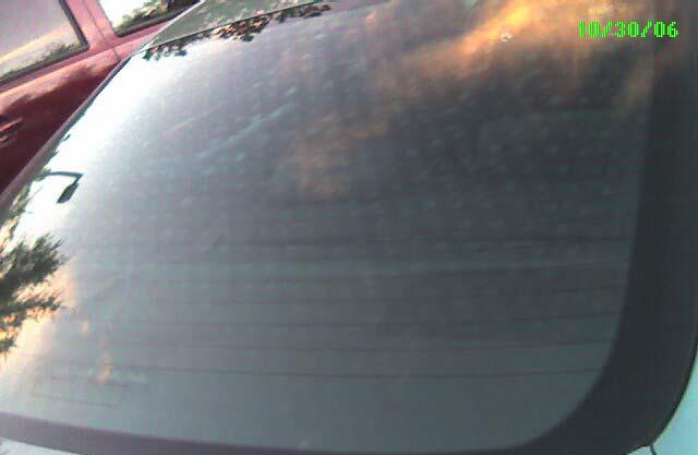 Typical dot quench pattern seen in a tempered Mercedes automotive back window when incoming light is reflected from the sky, especially when the sun is not directly shining on the glass.