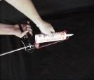 Pull back the push rod of the frame-style caulking gun to its full extension.