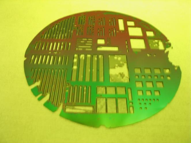 The pinholes result from defects in the SiO 2, allowing the TMAH to attack the underlying silicon and etch through the wafer from both sides.