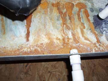 Observed rust in the bottom of the secondary drain pan of the attic portion of the north AC unit.