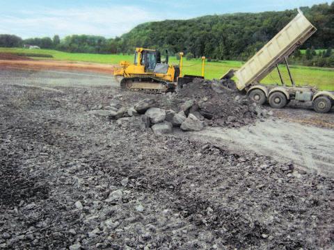 Soft slate with a grain size of up to 350 mm resulting from a tunnel excavation is therefore transported to the relevant areas where it is heaped up by means of dozers and then pre-compacted and