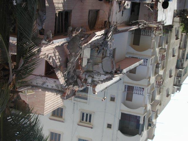 Poor quality of concrete (Photograph by Goel). Figure 9. Part of the building shown in Figure 6 fell on the neighboring building indicating presence of torsional motions (Photograph by Goel).