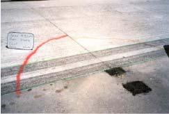 The reason for the longitudinal cracking was found to be associated with built-in curling of the slabs, and to a lesser extent, to the half axle loading.