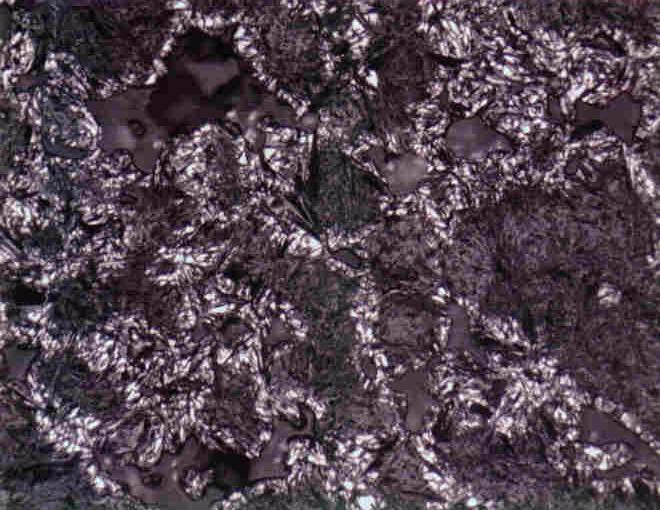 Figure 10: Microstructure of Premix #2-4 (2.0 w/o Copper - 0.9 w/o Graphite). Original Magnification 500X. Retained Austenite Present (White Regions).