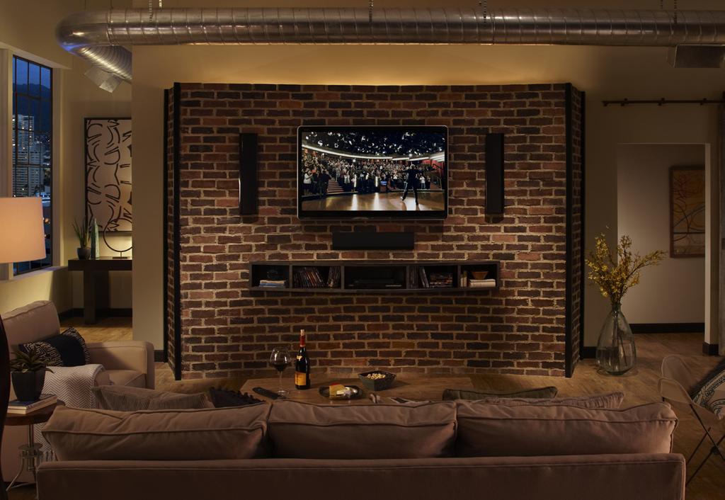 uniquely-curved Eldorado Brick wall, a flat screen TV, surround sound speakers and component