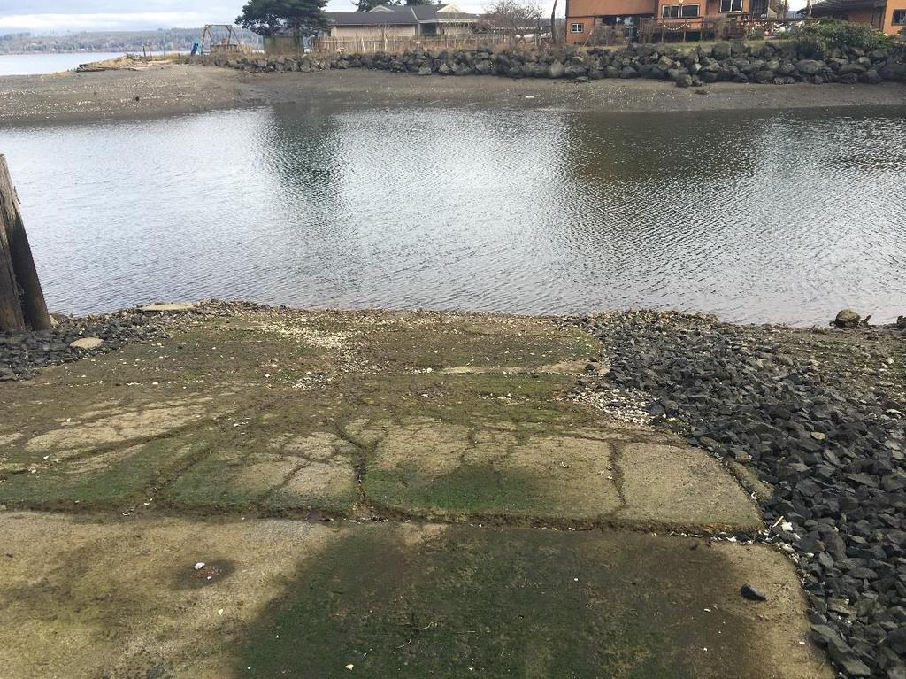 Deteriorated concrete boat ramp with cracks, spalling, and