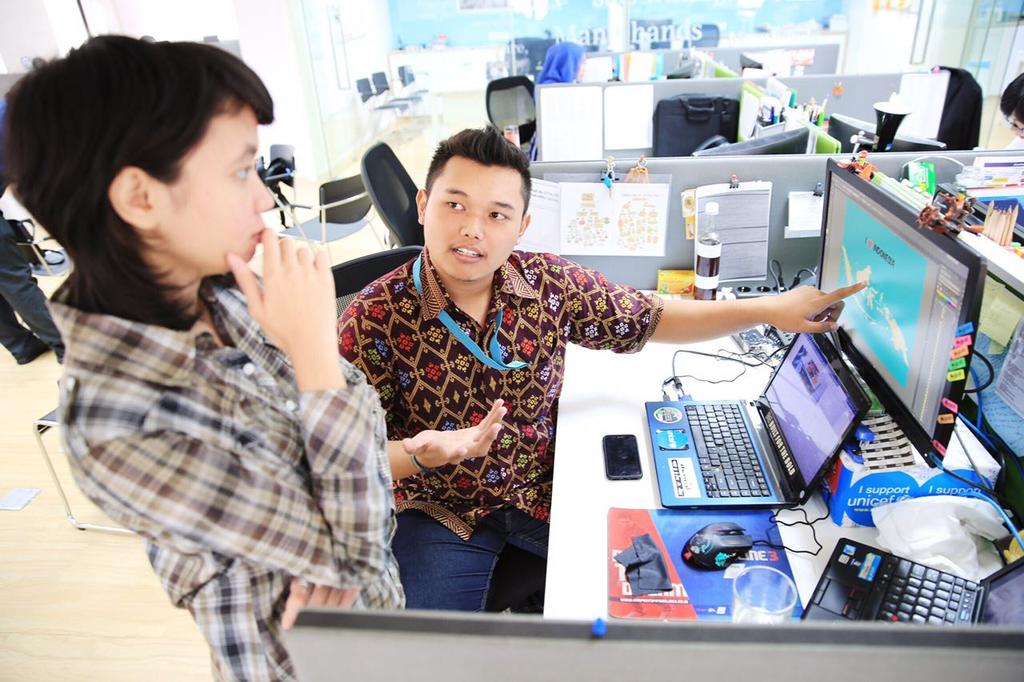 Mohammad lham Akbar Junior, National UN Youth Volunteer, discussing with his colleague in the United Nations Children s Fund (UNICEF) Indonesia Country Office.