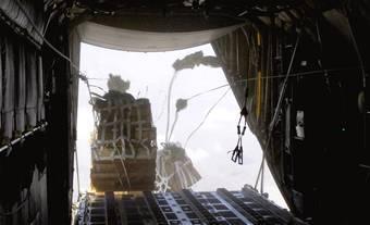 Joint Precision Air Drop System bundles fall out of the back of a C-130 Hercules Aug. 25.