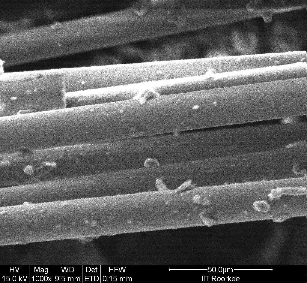 fibre epoxy composite with fibres densely embedded in epoxy matrix with epoxy surrounding completely the fibres which maintain their circularity and suggest good strength. The SEM image (Fig.