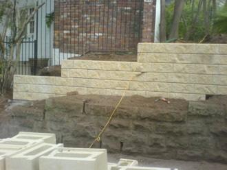 Step 7 To secure the blocks and bind them to the concrete footing, small aggregate concrete is poured down the holes in the blocks, binding the vertical starter bars to the concrete wall, this is
