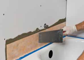 Install KERDI-BAND at inside wall corners and wall/ceiling junctions* using unmodified thinset mortar, centered over the joints.