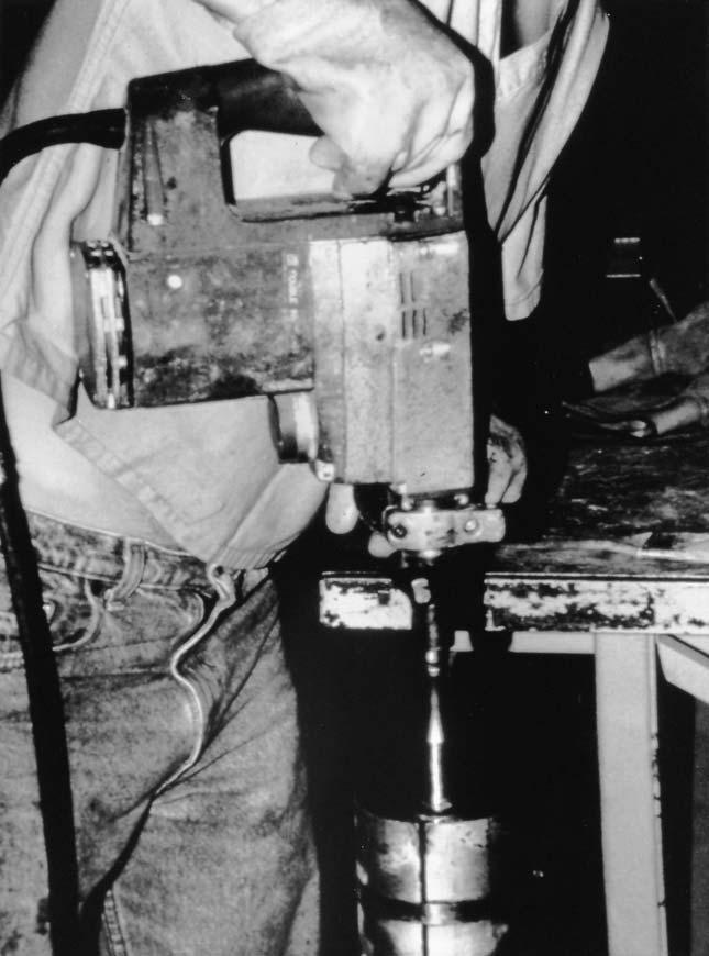 FIG. 1 Vibrating Hammer for Molding RCC Samples one-half and three-fourths of its volume, respectively. For the fourth lift, overfill the mold by mounding the concrete above the top of the mold.
