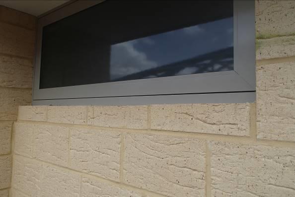 Photograph 1 shows no weepholes above a sill flashing.