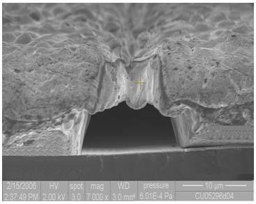No deposited material was observed at the bottom of the trench (see Fig. 9 and 10). Figure 10. SEM cross section image of 15μm wide by 11μm high Ni plated trenches sealed after indium reflow.