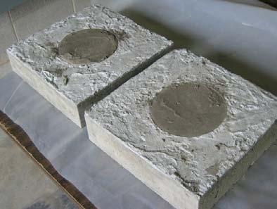 To model relative shrinkage of concrete and grout in a shear pocket, a 12 in. by 12 in. by 4 in. deep block of concrete was cast with a centered 6 in. diameter circular cutout.