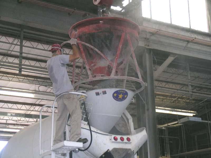 Figure 3-27 Type III cement being added to a ready mix truck. For the first specimen, electric rod vibrators were solely used to consolidate the concrete.