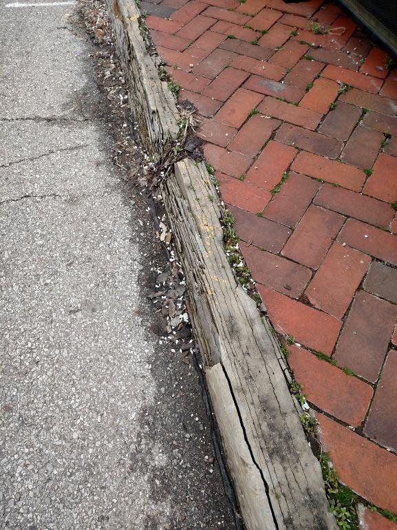 Deteriorated curb where damage extends throughout full depth of reveal; Visible planal damage for sandstone curb extending the full height of the reveal. b.