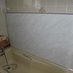 between the bottom edge of the panel and the bath or shower top and filled using