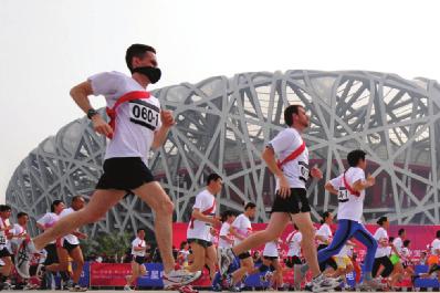 FIGURE 13 Effects of Air Pollution A runner in the Beijing Olympic Games wears a mask to protect his respiratory system from air pollution. Beijing has severe air pollution.