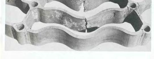 The cast portion of the grid suffered surface attack from the salt and soot deposits entrapped in the surface imperfections. Thermal fatigue fractures occurred at the center of the cast sections.