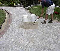 Continue sweeping and compacting until the joints are full. Stop the compactor and spot check the pavement with a 2 putty knife.