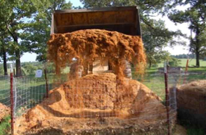 Figure 7. Turning the pile with a front-end loader. Figure 8. A hollow, brittle femur bone following 150 days of composting with pine shavings and poultry litter mixture.