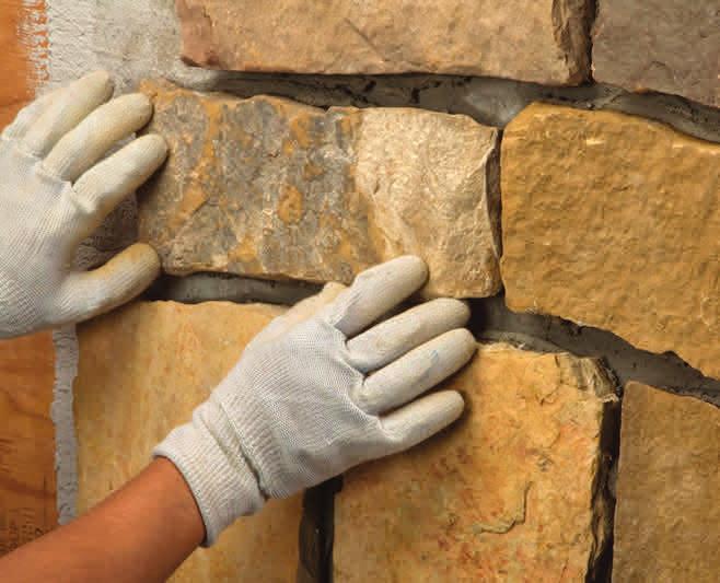 Press the corner piece onto the wall, rotating back and forth slightly, and forcing some of the mortar to squeeze out.