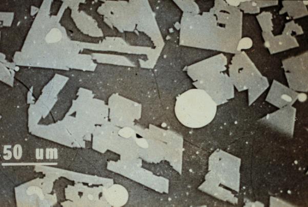 The angular spinel crystals and metal droplets are shown at higher magnification in Figure 23.