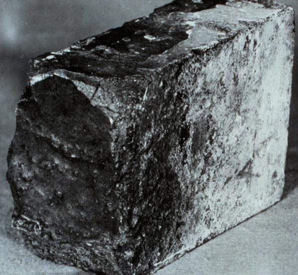 One brick from a mid-barrel location in a 50-ton AOD reactor is shown in Figure 26. The continuous glassy slag coating on the hot face is typical for AOD service.