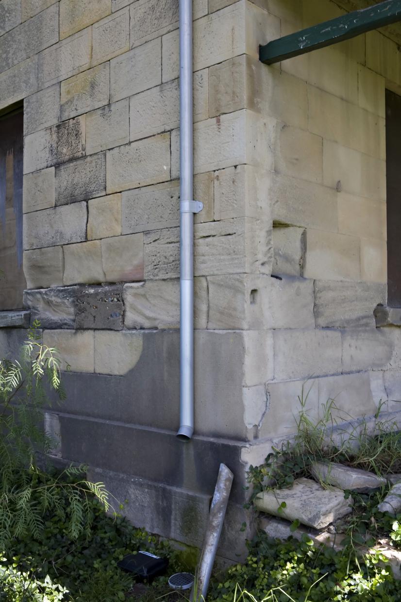 Figure 18- Image showing dampness around window, and inappropriate cement render repair to lower courses of sandstone.