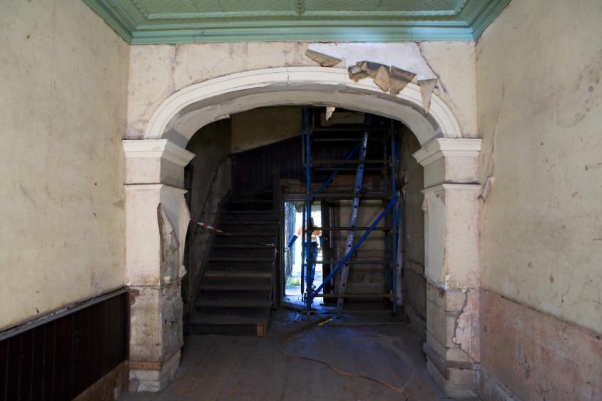 Figure 59- View to southern external door, showing archway with peeling paint and