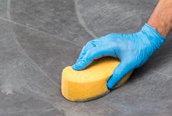 a firm cellulose sponge, taking care not to remove the grout.