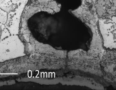 the graphite nodules at the point of fracture (see close up in lower right hand corner of micrograph).