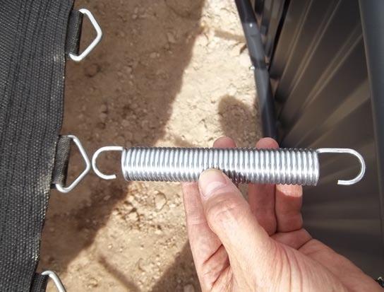 (See photo) Make sure the small hook is attached to the jump mat first and then using the spring