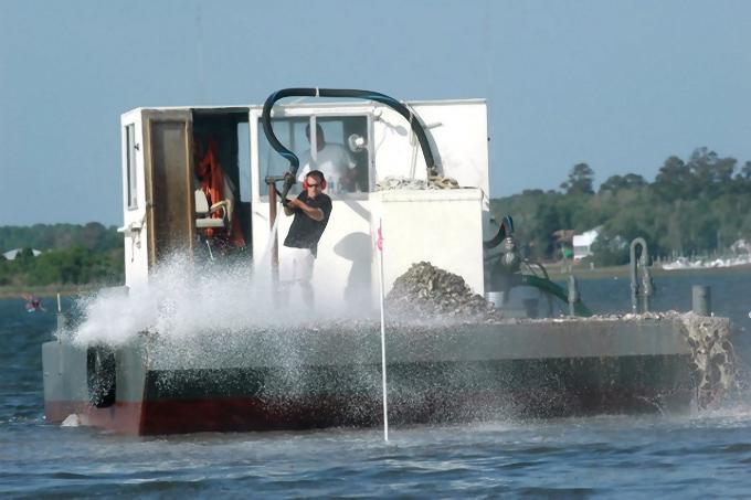 barge sprays off oysters shells to build a reef in Dicks