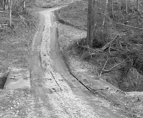 Note the BMPs used on this road: - Gentle sloping grades. Figure 5BB: A forest road and stream crossing - Turnout (on right) to divert runoff upslope of the stream.