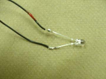 2) Solder each of the LED legs to a piece of hook-up wire. CHECK WHICH LED LEG IS LONGEST, AND LABEL THE HOOKUP WIRE CONNECTED TO IT (for example, you could use a blob of liquid tape, as shown).
