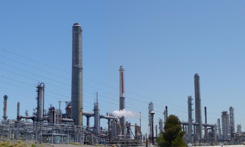 The Shell oil refinery at Martinez, California. The tapering vertical elements are smokestacks to create draft for heating units.