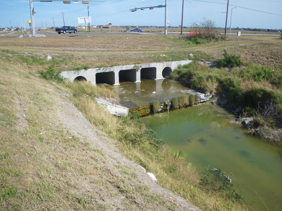 OCB051 OCB051 is located at the Kostoryz Rd and Saratoga Blvd intersection. There are several openings that flow out from under Kostoryz Rd.