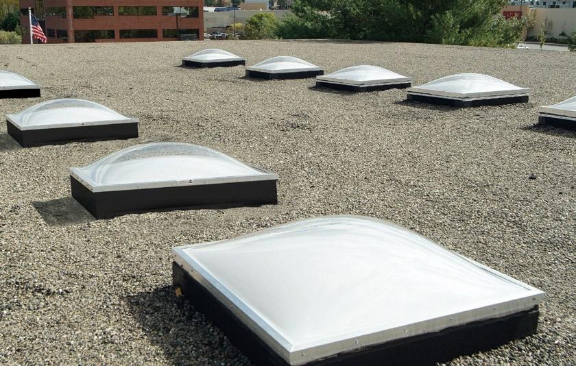 Photo depicts installation with ten CM dome skylights. Flat roof patterned toplighting Metro-lite fixed series Heavy-duty welded aluminum hatch and curb flashing.