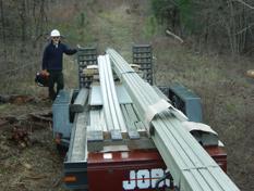 Figure 11 FRP bridge materials being delivered to a staging area. foundation, to carry some materials to the far bank, and to stand the trusses up on the foundations (figure 12).