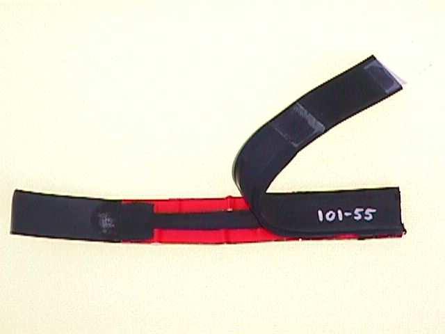 of double-sided self-adhesive tape (with the protective tape retained on one surface) is attached at both edges of one of the strips of Santoprene. Figure 1.