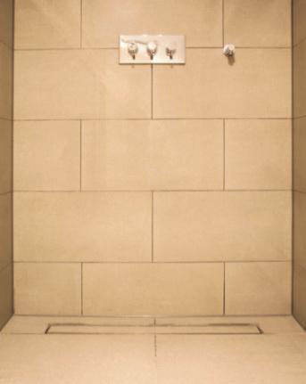 The system offers two design options due to a reversible channel cover rail. One side has a brushed stainless steel surface; the other can be tiled to match the entire shower base.