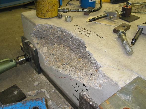 Upon removal of the concrete piece in Figure 10(b), the failure surface revealed a sharp, vertical face corresponding to the rear crack face.
