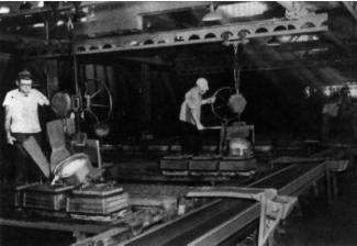 Before pouring, molten iron is transported from the melting area in a ladle and then distributed to pouring ladles suspended from an overhead conveyor system.