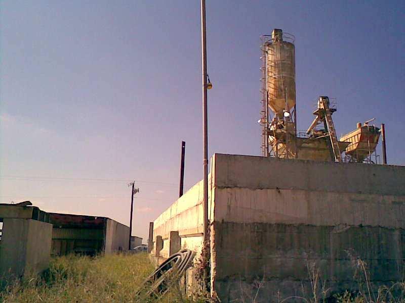 This photo shows the batch plant in the background, with the rock pile retaining