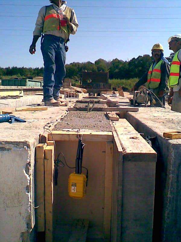 Wireless Maturity Meter deployed in a beam. Meter is approximately 800 feet from the base node. The laborers shown simply inserted the maturity sensor into the concrete after placement.