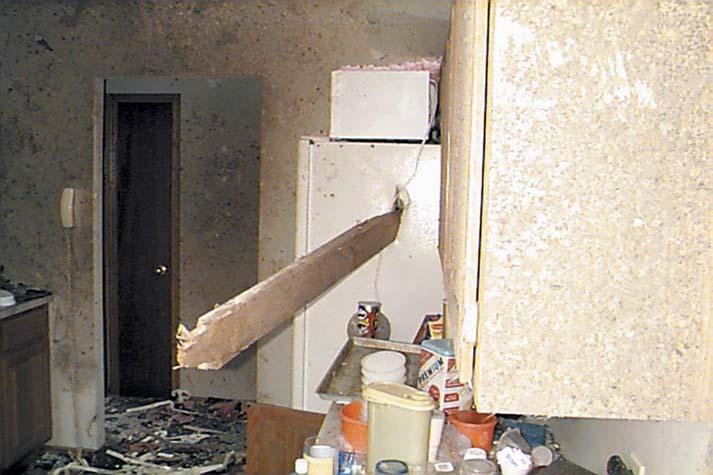 Chapter 2: Effects of High Winds Figure 2-2 Example of damage from windborne missile. A 2-inch by 6-inch board penetrated a refrigerator.